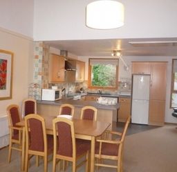 A kitchen and dining area with a wooden dining table and chairs at 20 Keswick Bridge in Keswick