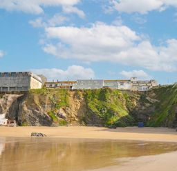 A beach with cliffs and buildings in the background at The View in Newquay