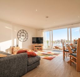 A living room with a sofa and dining area at The View in Newquay