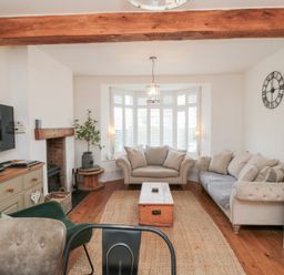A living room with a television and sofa at Harriet's Cottage in Briggswath