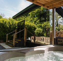 An outdoor area with a hot tub and seating at Reflection in Longtown