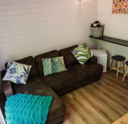 A living room with a brown sofa and a table at Reflection in Longtown