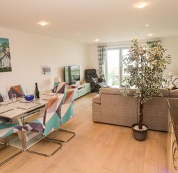 A living room with a dining area and sofa at Ocean Seven in Newquay