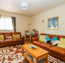 A living room with two leather sofas a wooden coffee table and a small dining table at Richmond Cottage in Burythorpe near Malton