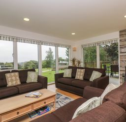 A living room with brown sofas a wooden coffee table and a fireplace at Hazel in Truro
