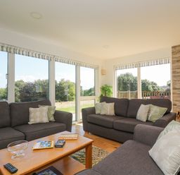 A living room with gray sofas a wooden coffee table and a wood burning stove at Rowan in Truro