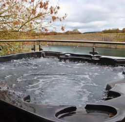 A hot tub overlooking water at Boavista in Carnforth