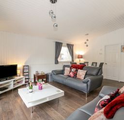 A living room with sofas a coffee table and a television at Sunset Lodge in Tattershall