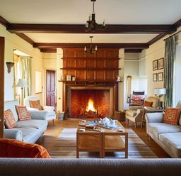 A living room with a fireplace and sofas at Great Bidlake Manor in Bridestowe, near Lydford