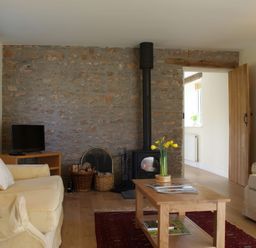 A living room with a television and stove at The Barn in Compton Bishop, near Cheddar