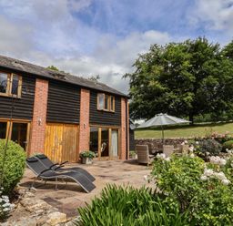 An outdoor area with a building and seating at The Old Log Shed in Honiton