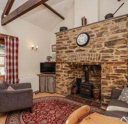 A living room with a fireplace and television at Miners Dry in Gulworthy, near Tavistock