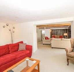 A sitting room with sofas a glass coffee table and a floor lamp at West Henstill House in Sandford Devon