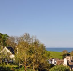 A coastal village with houses trees and the sea in the background at Bramble Cottage in Ringmore