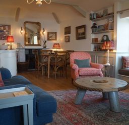 A living room with a dining table and chairs at Coach House Cottage, Strete, near Dartmouth