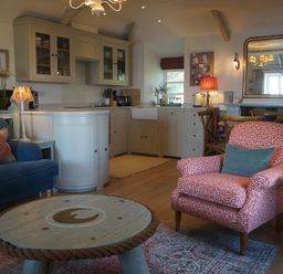 A living room with a sofa and coffee table at Coach House Cottage Strete, near Dartmouth
