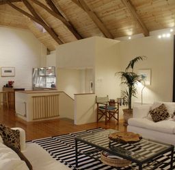 A living room with white sofas and a striped rug at The Barn in Aveton Gifford