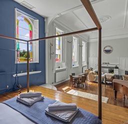 A living room with a bed and table at The Music Room in Aveton Gifford