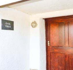 An entrance with a door and a sign at Oak Tree in Halwell