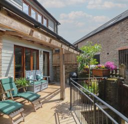An outdoor patio with seating and planters at Fixit Cottage in Kingsbridge