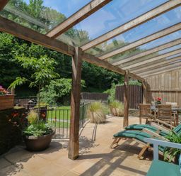 An outdoor patio with a table and chairs at Fixit Cottage in Kingsbridge
