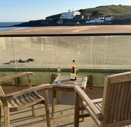 An outdoor area with chairs and a table overlooking a beach at 5 Burgh Island Causeway Bigbury-on-Sea