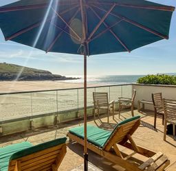 An outdoor terrace with sun loungers and a view of the sea at 5 Burgh Island Causeway Bigbury-on-Sea