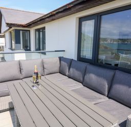 An outdoor seating area with a sofa and table at 27 Burgh Island Causeway in Bigbury-on-Sea