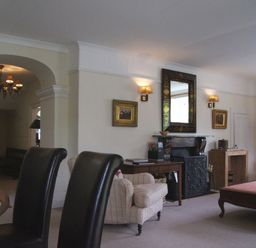 A living room with chairs a fireplace a mirror and a lamp at Maristow Barton in Milton Combe near Lopwell Dam