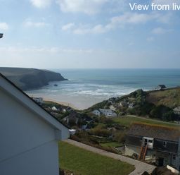 A coastal view with houses cliffs and sea at Seagulls Perch in Mawgan Porth