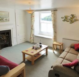 A living room with two sofas a coffee table and a window view at Balcony Cottage in Kingsand And Cawsand