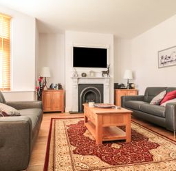 A living room with two sofas a wooden coffee table and a fireplace at 33 Crescent Gardens in Bath