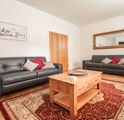 A living room with two leather sofas a wooden coffee table and a large rug at 33 Crescent Gardens in Bath