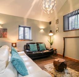 A living room with two sofas wooden coffee table and plants at Elvan Cottage in Liskeard