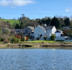 A house with a garden and trees beside a body of water at Clamoak Cottage Clamoak near Bere Alston