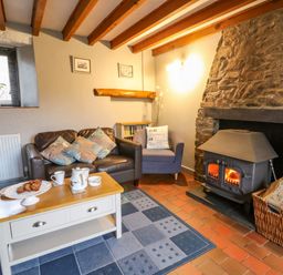 A living room with a fireplace and seating at Old Farmhouse Cottage 