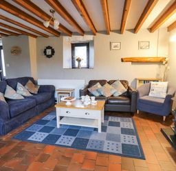 A living room with sofas and a coffee table at Old Farmhouse Cottage