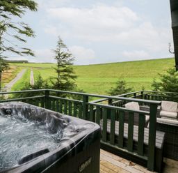 An outdoor area with a hot tub and seating at Oak Lodge in Pennington near Ulverston