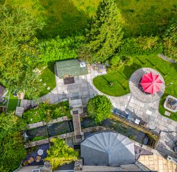 An aerial view of a garden with patio areas a red umbrella seating and a small stream at Eden Mill Millers Beck Kendal