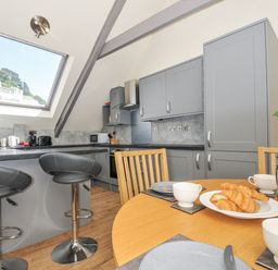 A kitchen with a table set for breakfast at Beach Retreat in Looe