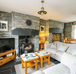 A living room with a fireplace and sofa at Garreg Ddu in Blaenau Ffestiniog