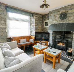 A living room with a sofa and fireplace at Garreg Ddu in Blaenau Ffestiniog