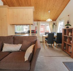 A living room with a sofa and dining area at The Cedars in South Lakeland Leisure Village