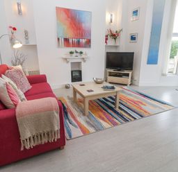 A living room with a sofa and television at Beachcomber in Marazion