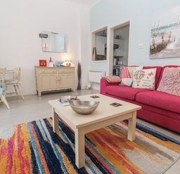 A living room with a sofa, coffee table, and dining table at Beachcomber in Marazion