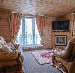 A living room with leather furniture and a television at The Cabin at East Hill Pride Four Elms Hill Nr. Sidmouth