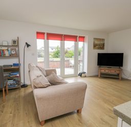 A living room with a sofa and television at Coney Garth Cottage in Beckermet