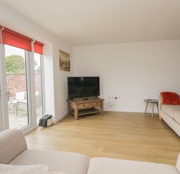 A living room with a television and two sofas at Coney Garth Cottage in Beckermet