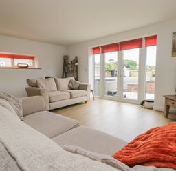 A living room with a sofa and a television at Coney Garth Cottage in Beckermet