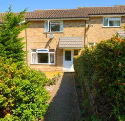 The front of a brick house with a white door and windows a path leads to the door and there are bushes on either side at Howards Hill West in Cromer